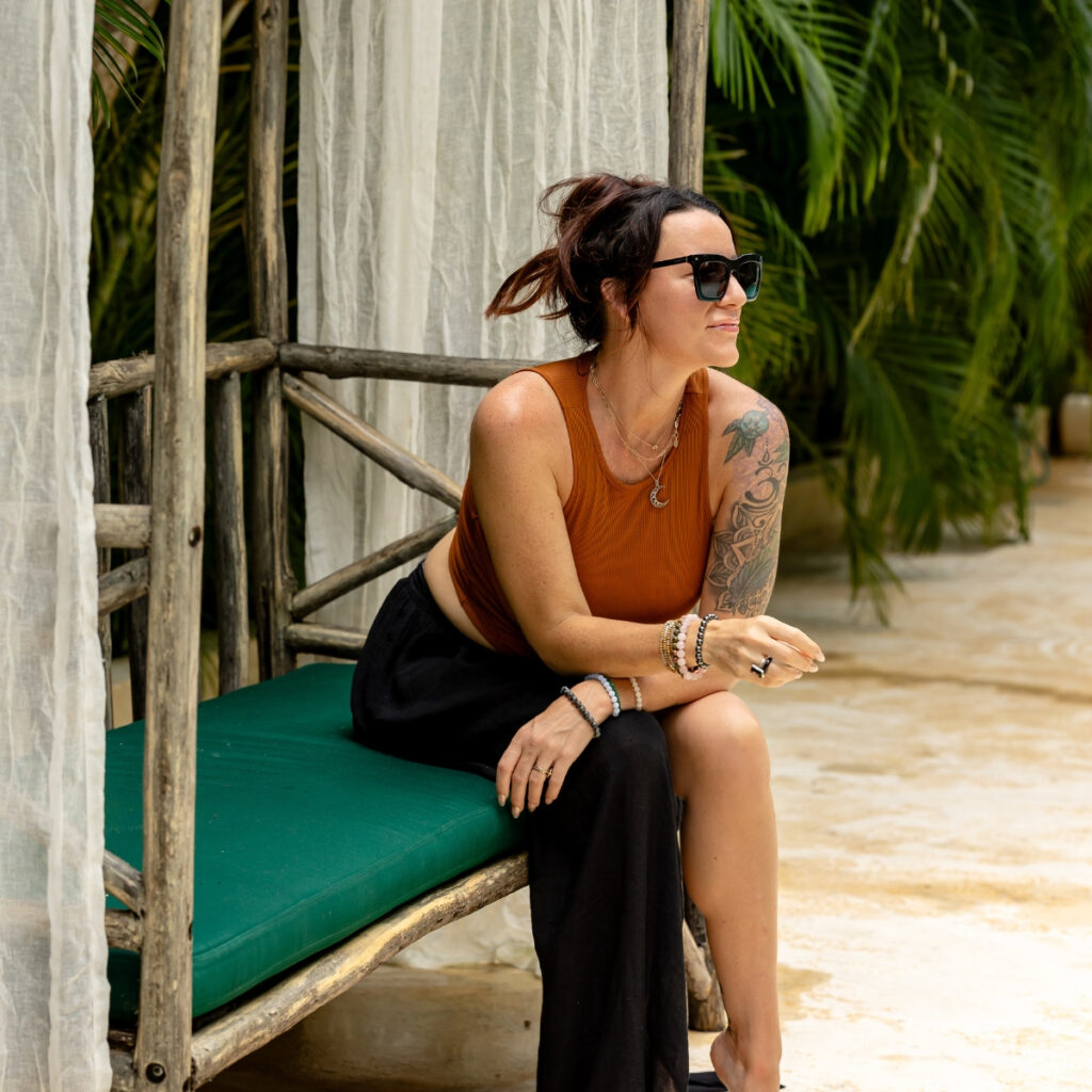 A woman relaxes on an outdoor bench, embodying the principles of balance and well-being central to understanding Ayurveda.