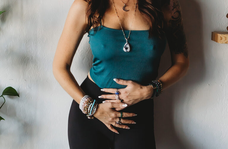 Woman with hands over her belly, symbolizing gut health and healing inflammation through gut-friendly practices.
